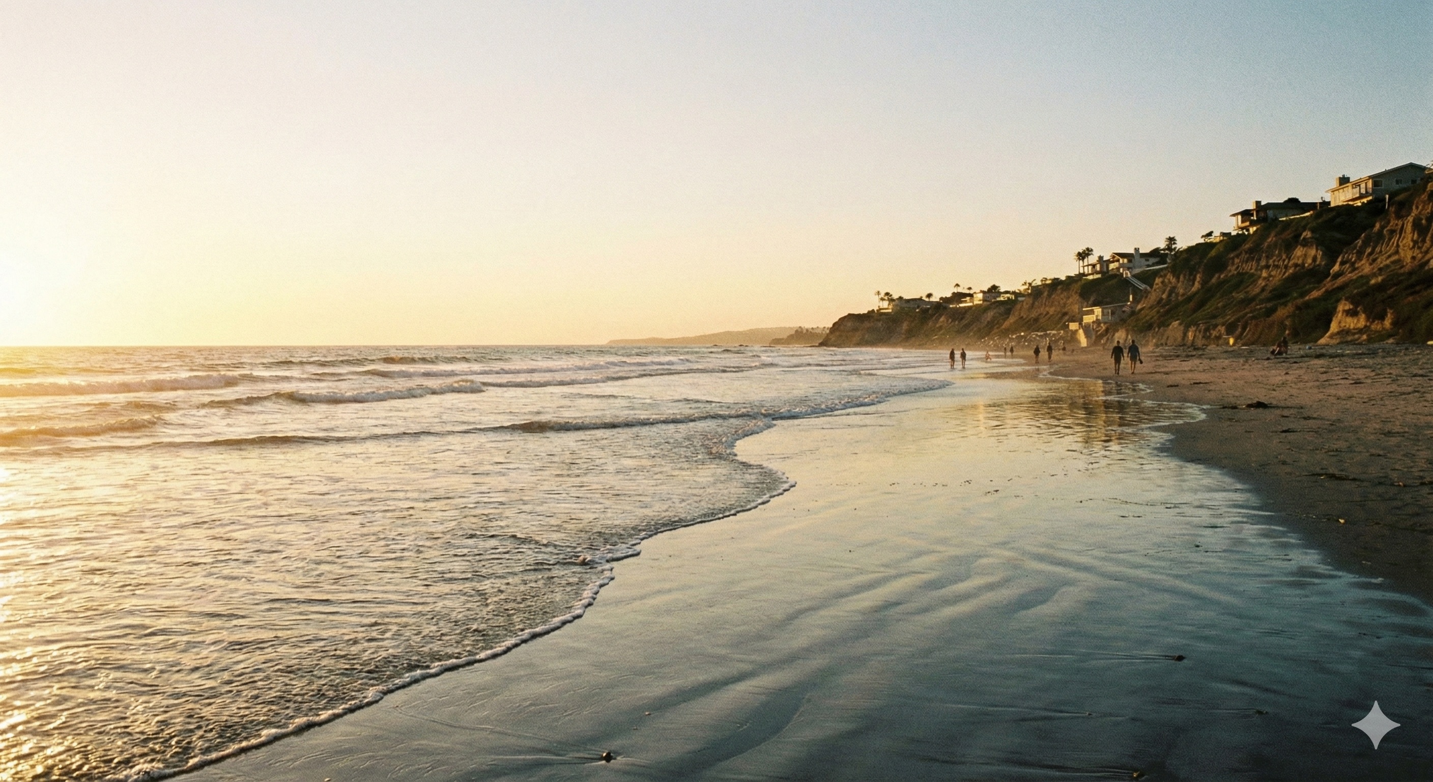 Del Mar beach at golden hour with gentle waves and coastal bluffs